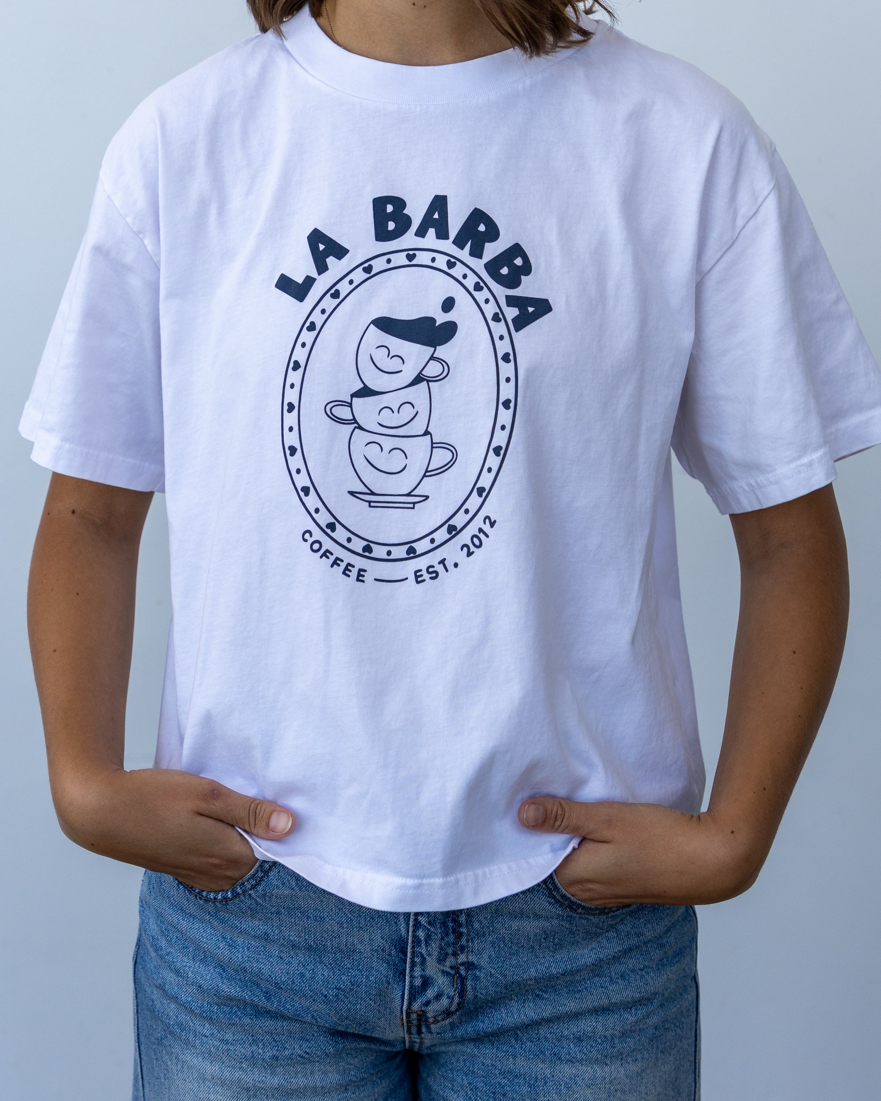 Person wearing a white t-shirt with 'La Barba Coffee' logo against a light gray background