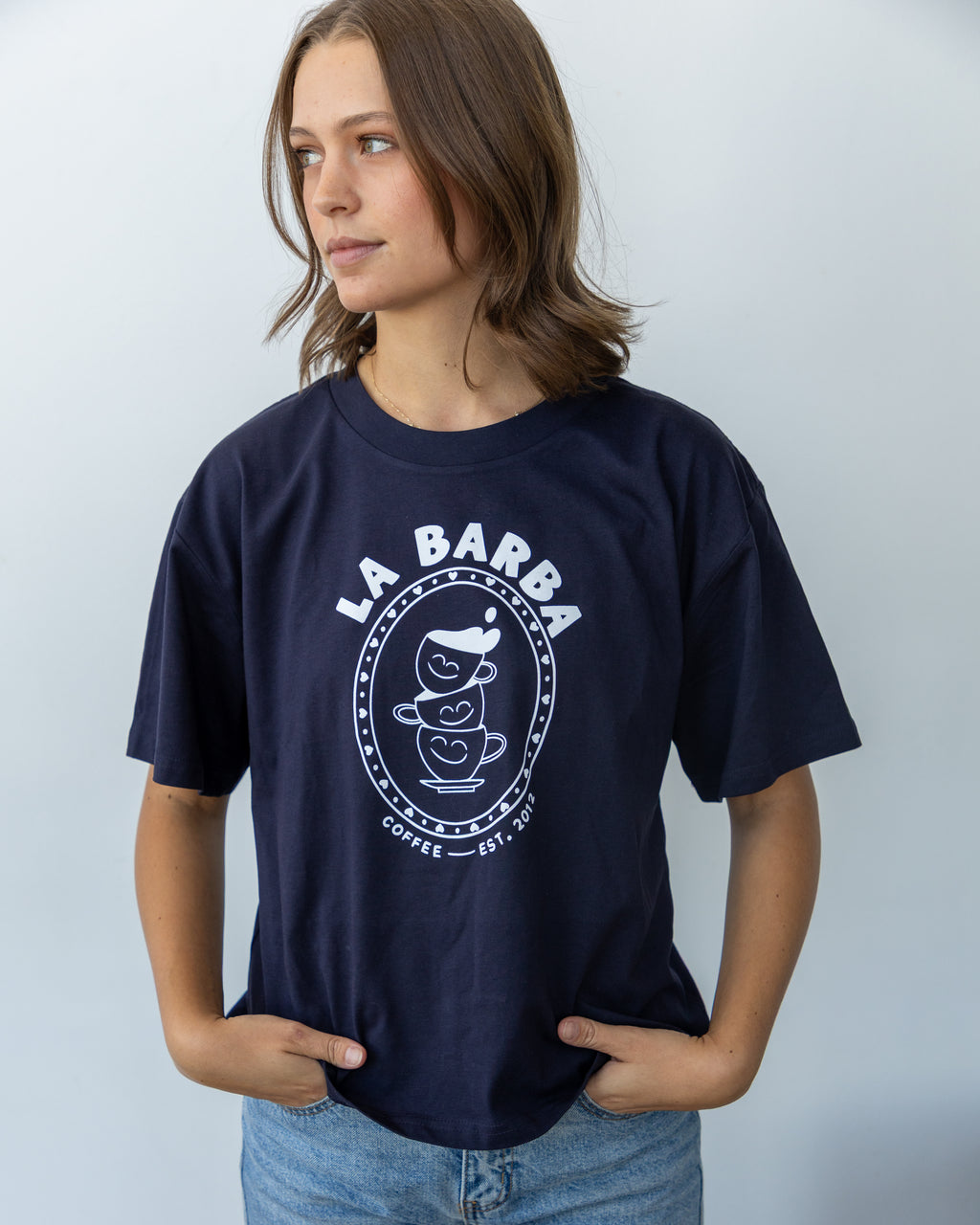 Person wearing a navy blue t-shirt with 'La Barba Coffee' logo against a light gray background