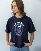 Person wearing a navy blue t-shirt with 'La Barba Coffee' logo against a light gray background