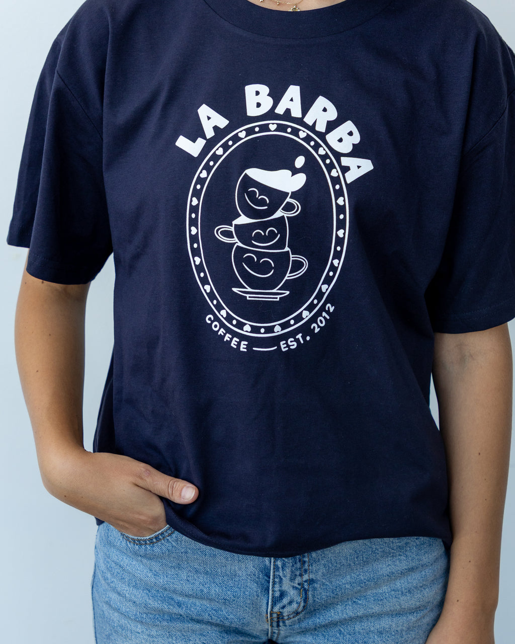 Navy blue t-shirt with 'La Barba Coffee' logo worn by a person against a light gray background
