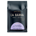The image features a 12oz bag of La Barba Coffee, specifically their Colombia Decaf Sebastian Ramirez. The bag is designed with a dark background, prominently displaying the brand name "La Barba" in large, elegant letters. It highlights the coffee's origin, Colombia, along with a description of the flavor profile, including notes of orange zest, chocolate, and nougat. The design exudes a premium and modern feel with a minimalist, sophisticated look.