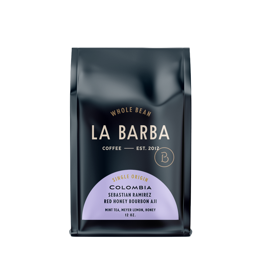 The image features a 12oz bag of La Barba Coffee, specifically their Colombia Sebastian Ramirez red honey bourbon aji. The bag is designed with a dark background, prominently displaying the brand name "La Barba" in large, elegant letters. It highlights the coffee's origin, Colombia, along with a description of the flavor profile, including notes of mint tea, meyer lemon, and honey. The design exudes a premium and modern feel with a minimalist, sophisticated look.