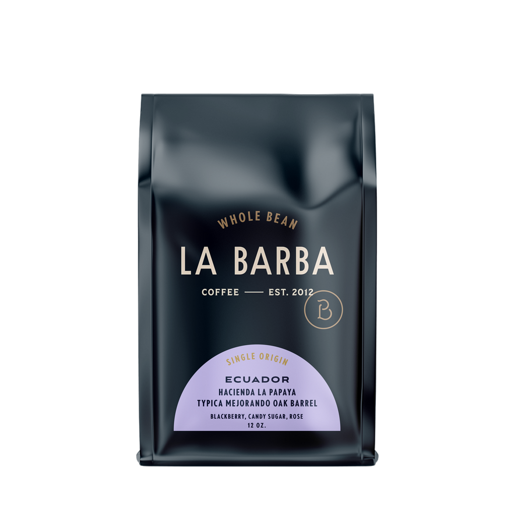The image features a 12oz bag of La Barba Coffee, specifically their Ecuador Hacienda La Papaya. The bag is designed with a dark background, prominently displaying the brand name "La Barba" in large, elegant letters. It highlights the coffee's origin, Ecuador, along with a description of the flavor profile, including notes of blackberry, candy sugar, and rose. The design exudes a premium and modern feel with a minimalist, sophisticated look.