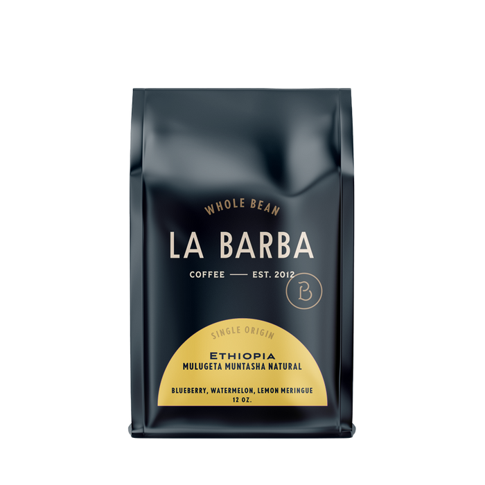The image features a 12oz bag of La Barba Coffee, specifically their Ethiopia Mulugeta Muntasha Natural single-origin coffee. The bag is designed with a dark background, prominently displaying the brand name 