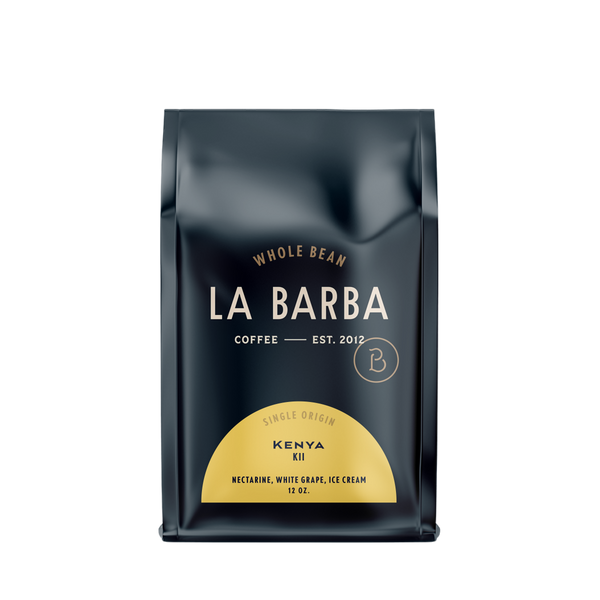 The image features a 12oz bag of La Barba Coffee, specifically their Kenya Kii. The bag is designed with a dark background, prominently displaying the brand name "La Barba" in large, elegant letters. It highlights the coffee's origin, Kenya, along with a description of the flavor profile, including notes of nectarine, white grape, and ice cream. The design exudes a premium and modern feel with a minimalist, sophisticated look.