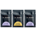 A set of three La Barba Coffee single-origin whole bean bags displayed side by side against a white background. Each bag features La Barba’s signature dark navy packaging. The left bag highlights Colombia Solsticio with flavor notes of sweet lemonade, green tea, and peach. The middle bag features Rwanda Kungahara Lot 12 with pineapple, rose, and green grape notes. The right bag presents Ecuador Sidra Natural with notes of apricot, orange, and cream soda.