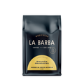 The image features a 12oz bag of La Barba Coffee, specifically their Rwanda Natural single-origin coffee. The bag is designed with a dark background, prominently displaying the brand name "La Barba" in large, elegant letters. It highlights the coffee's origin, Rwanda, along with a description of the flavor profile, including notes of Blueberry Jam, Hibiscus, and Watermelon. The design exudes a premium and modern feel with a minimalist, sophisticated look.
