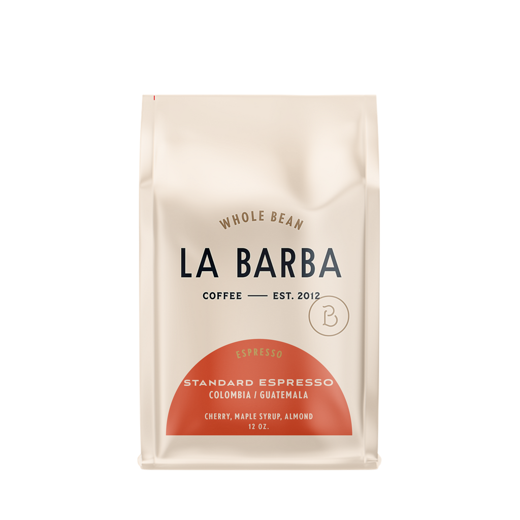The image features a 12oz bag of La Barba Coffee, specifically their Standard Espresso Blend. The bag is designed with an ivory white background, prominently displaying the brand name "La Barba" in large, elegant letters. It highlights the coffee blend's origins, Colombia and Guatemala, and includes a description of the flavor profile, including notes of Cherry, Maple Syrup, and Almond. The design exudes a premium and modern feel with a minimalist, sophisticated look.
