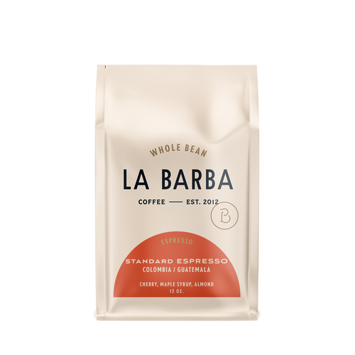 The image features a 12oz bag of La Barba Coffee, specifically their Standard Espresso Blend. The bag is designed with an ivory white background, prominently displaying the brand name "La Barba" in large, elegant letters. It highlights the coffee blend's origins, Colombia and Guatemala, and includes a description of the flavor profile, including notes of Cherry, Maple Syrup, and Almond. The design exudes a premium and modern feel with a minimalist, sophisticated look.