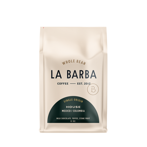 The image features a 12oz bag of La Barba Coffee, specifically their House Blend. The bag is designed with an ivory white background, prominently displaying the brand name "La Barba" in large, elegant letters. It highlights the coffee blend's origins, Mexico and Colombia, and includes a description of the flavor profile, including notes of Milk Chocolate, Toffee, and Stone Fruit. The design exudes a premium and modern feel with a minimalist, sophisticated look.
