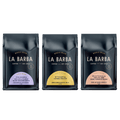 Three packages of La Barba coffee with different country labels on a white background